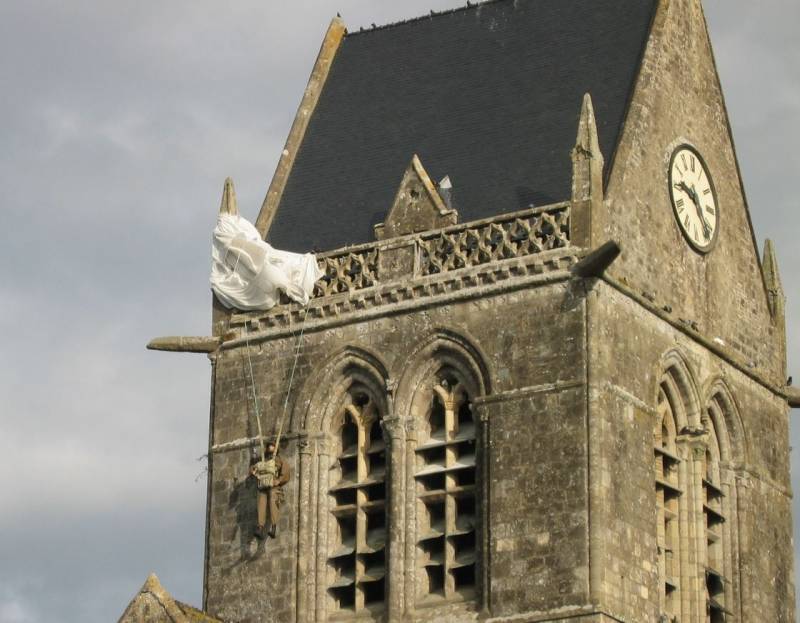 El paracaidista suspendido del campanario de la iglesia Sainte-Mère-Église, correspondiente en la realidad al soldado John Steel de la 82ª División, se ha convertido en una imagen significativa de la operación aerotransportada norteamericana en las horas El paracaidista suspendido del campanario de la iglesia Sainte-Mère-Église, correspondiente en la realidad al soldado John Steel de la 82ª División, se ha convertido en una imagen significativa de la operación aerotransportada norteamericana en las horas