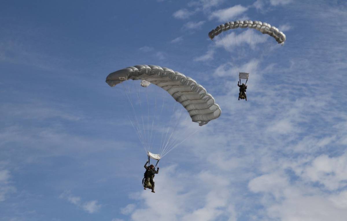 2 miembros de la CRAV llegando a tierra, utilizando sus paracadas cuadrangulares de salto manual.