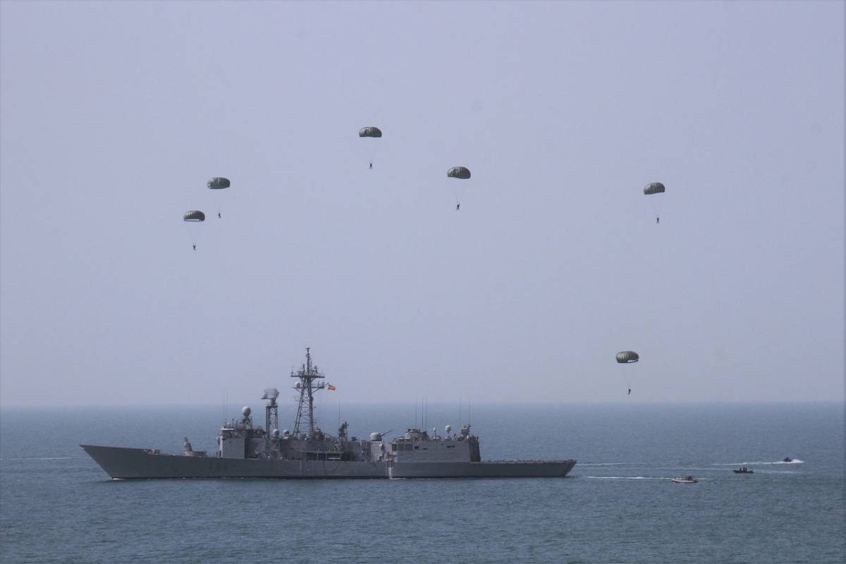 Tras lanzarse de un C295, varias paracaidistas estn a punto de caer junto a la fragata Reina Sofa, que tiene en el mar varias de sus lanchas para recogerlos.(Fotografa: Julio Maz Sanz)