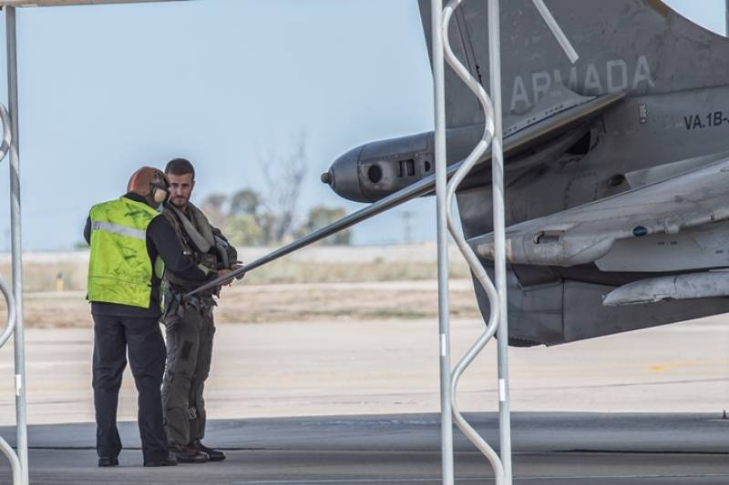 El piloto ya se encuentra preparado para subirse al avin y recibe las ltimas indicaciones. Como no podra ser de otra manera, la relacin y confianza entre piloto y equipo es absoluta. Se aprecia en la imagen una protuberancia  en la parte posterior del alern trasero, en ella se encuentran la vlvula de aire a reaccin del control de aspas, toberas de babor y estribor, antenas RWR traseras y tobera trasera de aire a reaccin del control de inclinacin.