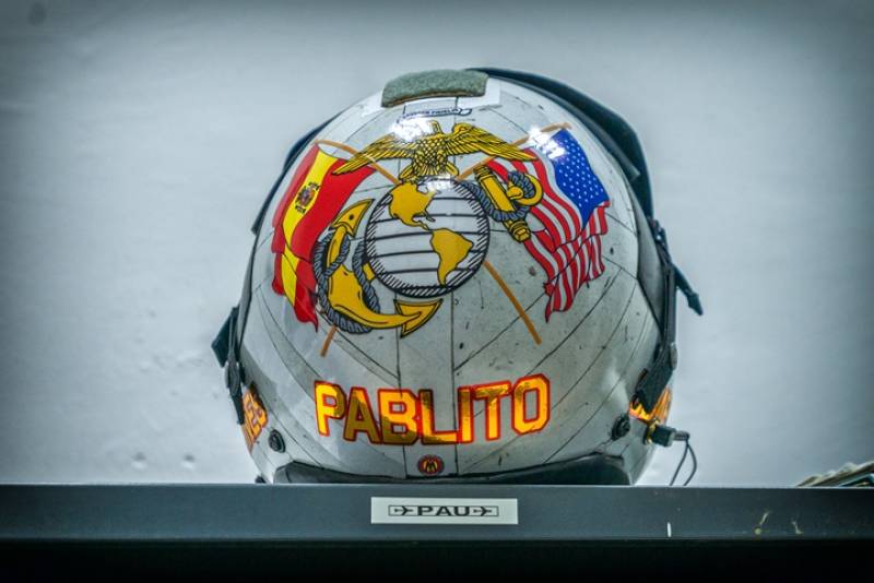 Casco de vuelo HGU-68P perteneciente a Paul “Pablito”, un piloto del Cuerpo de Marines de los Estados Unidos, que ha estado de intercambio en la Novena escuadrilla. Normalmente hay destinado un Marine en España y un Piloto de la Armada Española en USA. El casco de la imagen fue decorado por Sergio Muriel, un artista que también ha decorado otros muchos cascos de la Novena Escuadrilla y otras unidades militares españolas. Este casco muy ligero, solo 998 gramos (sin máscara) y está fabricado con fibras de grafito y aramida. Ayuda a prevenir el G-LOC, protege a la cabeza contra golpes, pero también aísla a los oídos del ruido. La visera protege la cara en el momento de la eyección y posterior caída al mar o tierra firme, y a los ojos contra los deslumbramientos y efectos perjudiciales de los rayos ultravioleta. Casco de vuelo HGU-68P perteneciente a Paul “Pablito”, un piloto del Cuerpo de Marines de los Estados Unidos, que ha estado de intercambio en la Novena escuadrilla. Normalmente hay destinado un Marine en España y un Piloto de la Armada Española en USA. El casco de la imagen fue decorado por Sergio Muriel, un artista que también ha decorado otros muchos cascos de la Novena Escuadrilla y otras unidades militares españolas. Este casco muy ligero, solo 998 gramos (sin máscara) y está fabricado con fibras de grafito y aramida. Ayuda a prevenir el G-LOC, protege a la cabeza contra golpes, pero también aísla a los oídos del ruido. La visera protege la cara en el momento de la eyección y posterior caída al mar o tierra firme, y a los ojos contra los deslumbramientos y efectos perjudiciales de los rayos ultravioleta.