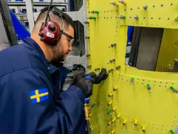 Operario trabajando en el fuselaje trasero de una aeronave de Saab.