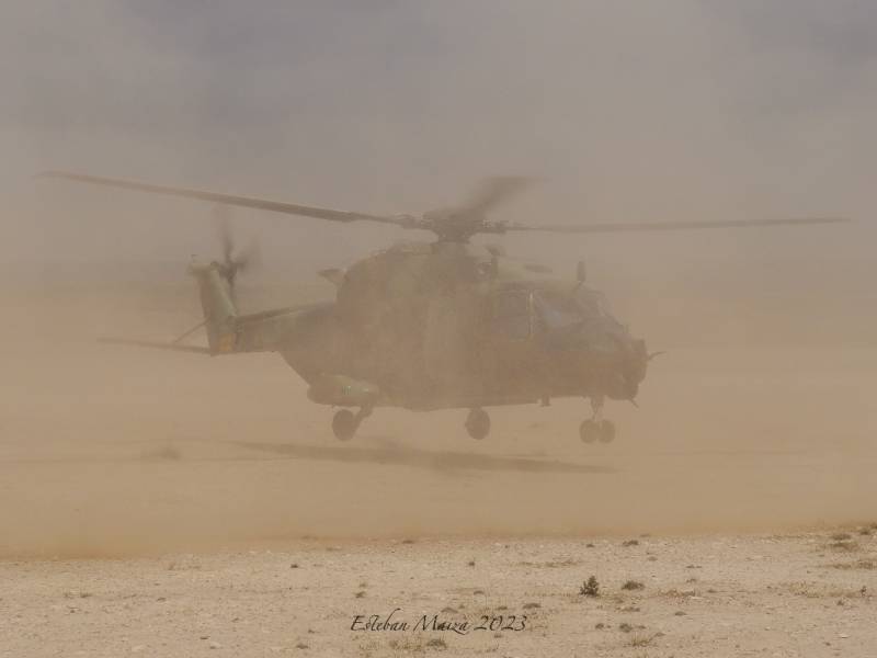 UN NH-90 del BHELMA III envuelto en una nube de polvo mientras despega.