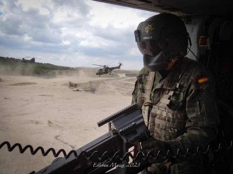 Un tirador de ametralladora M3M del BHELMA III con un �Cougar� espa�ol y un �Chinook� brit�nico despegando de fondo.