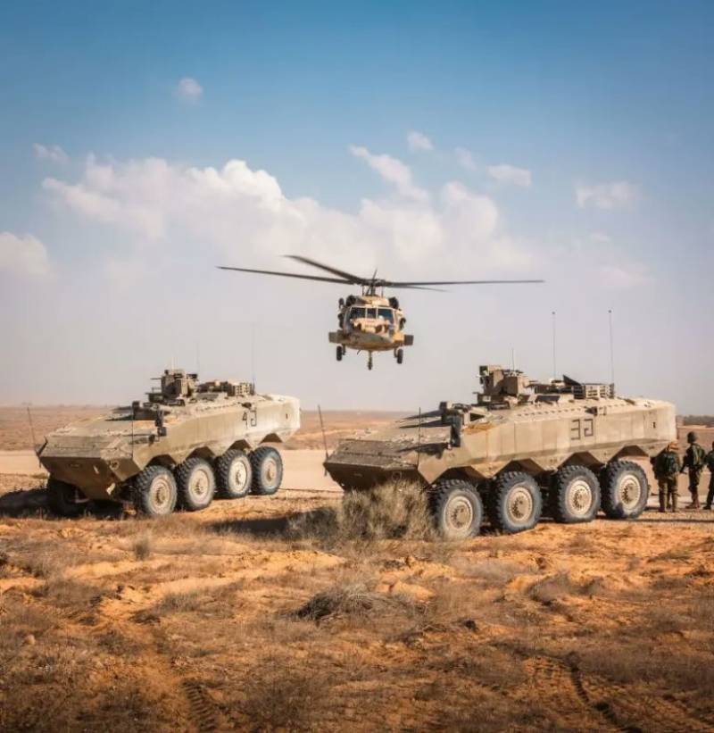 Dos de los 8x8 Eitan de la IDF, detrs se ve un helicptero UH-60 Yanshuf de dicha fuerza. (foto IDF)