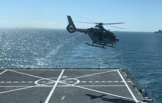 Uno de los nuevos H135 evoluciona sobre la cubierta del �Galicia�, al fondo se ve el �Juan Carlos I�. (foto Armada)
