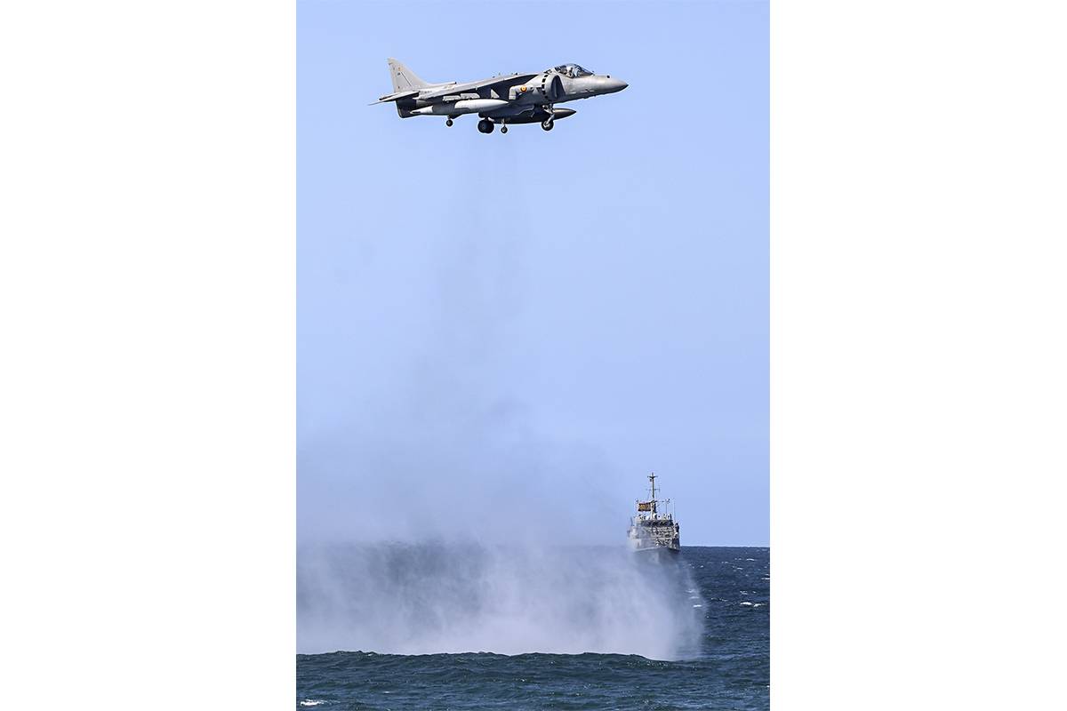 Exhibición de vuelo estacionario de un AV-8B frente a Gijón, al fondo a la derecha se ve un cazaminas de la Armada. (foto Rubén Galindo) Exhibición de vuelo estacionario de un AV-8B frente a Gijón, al fondo a la derecha se ve un cazaminas de la Armada. (foto Rubén Galindo)