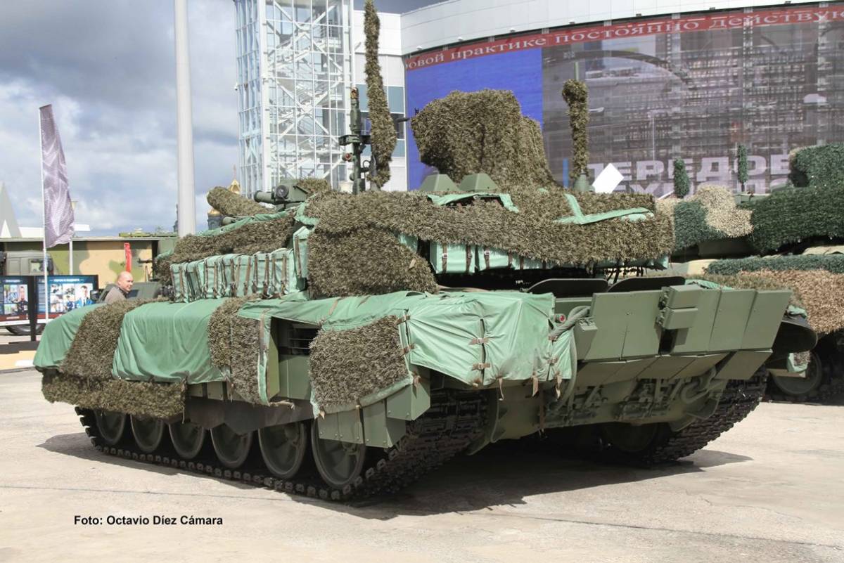Vista posterior de un T-90M en el que se aprecia el tejido que cubre buena parte de su estructura, los módulos de blindaje de los costados o las gruesas planchas que tiene en la zona trasera. (Octavio Díez Cámara) Vista posterior de un T-90M en el que se aprecia el tejido que cubre buena parte de su estructura, los módulos de blindaje de los costados o las gruesas planchas que tiene en la zona trasera. (Octavio Díez Cámara)