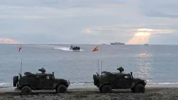 Dos VAMTAC de Infantera de Marina del Ddalo 25 durante un desembarco anfibio con el LHD Juan Carlos I de fondo en el mar. Foto: Armada