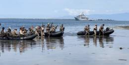 Soldados del 33 Rima y de las FF. AA. dominicanas desembarcan de un bote Zodiac, en el fondo el buque Dumont d