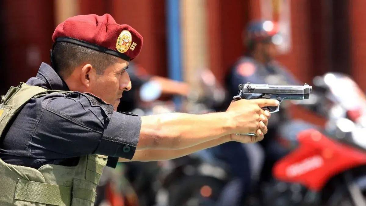 Un policía nacional del Perú empuñando una pistola. Un policía nacional del Perú empuñando una pistola.