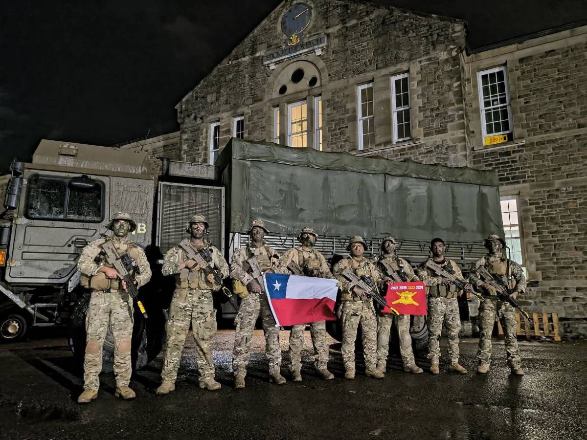 La patrulle chilena posando con la bandera frente a un cuartel galés. (foto: Ejército de Chile) La patrulle chilena posando con la bandera frente a un cuartel galés. (foto: Ejército de Chile)