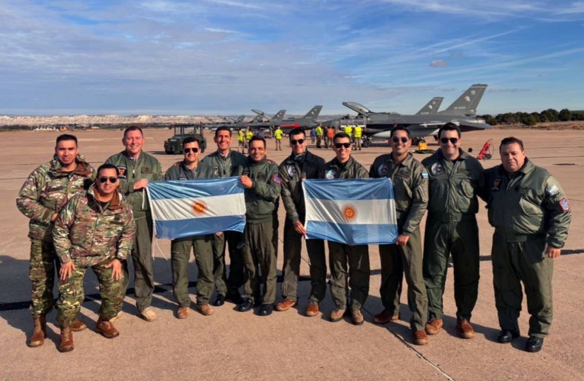 Los pilotos de la FAA muestran banderas albicelestes tras aterrizar en Zaragoza. Al fondo se distinguen los seis F-16. (Foto: Luis Petri) Los pilotos de la FAA muestran banderas albicelestes tras aterrizar en Zaragoza. Al fondo se distinguen los seis F-16. (Foto: Luis Petri)