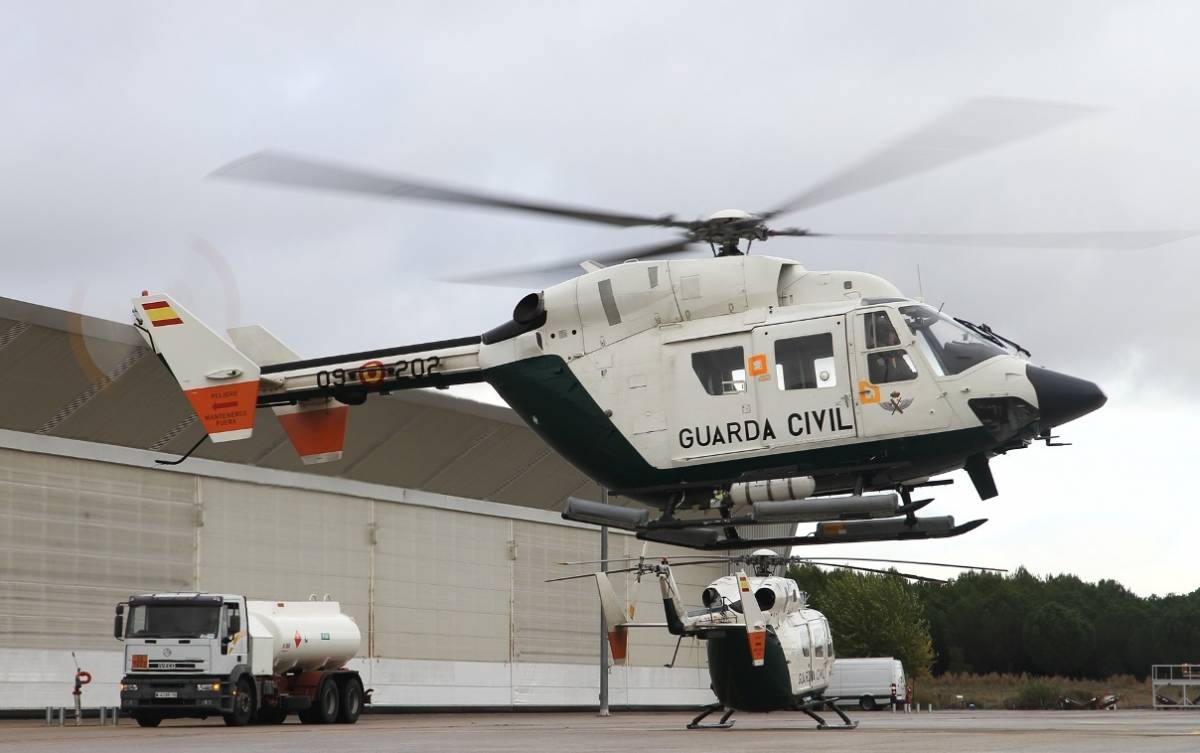 Dos de los BK-117 del SAER, uno volando en primer plano, mientras que al fondo se ve otro aparcado en la plataforma de Torrej�n. (foto Julio Ma�z)