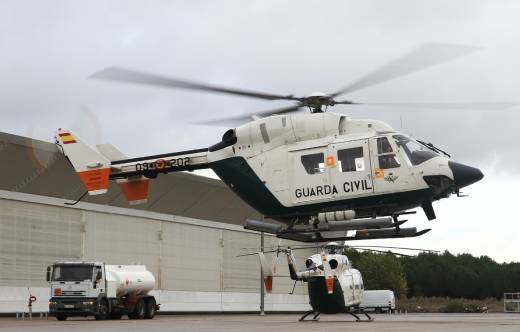 Dos de los BK-117 del SAER, uno volando en primer plano, mientras que al fondo se ve otro aparcado en la plataforma de Torrej�n. (foto Julio Ma�z)