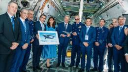 Presidente Jos� Antonio Kast posando con una maqueta del KC-390 Millennium junto a la comitiva de Embraer y Fuerza A�rea de Brasil, FIDAE 2026.