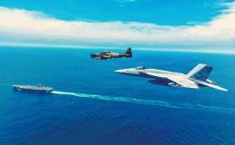 Un avi�n apoyo a�reo Embraer A 29 Super Tucano del Grupo de Caza 23 de la FAE vuela en formaci�n con un caza polivalente Boeing F/A-18E Super Hornet del  VFA 137 �Kestrels", en el fondo el portaaviones USS Nimitz (CVN 68). (Cr�ditos: SOUTHCOM)