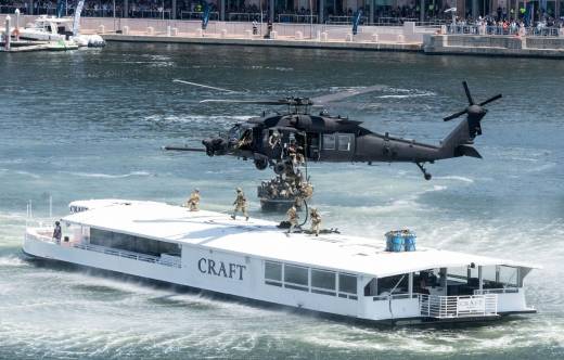 Helic�ptero Sikorsky MH-60L/M Black Hawk desembarca un equipo de asalto del 10th SFG en una embarcaci�n tur�stica en la Bah�a de Tampa mientras una lancha SOC-R ofrece cobertura. (Cr�ditos: SOCOM)