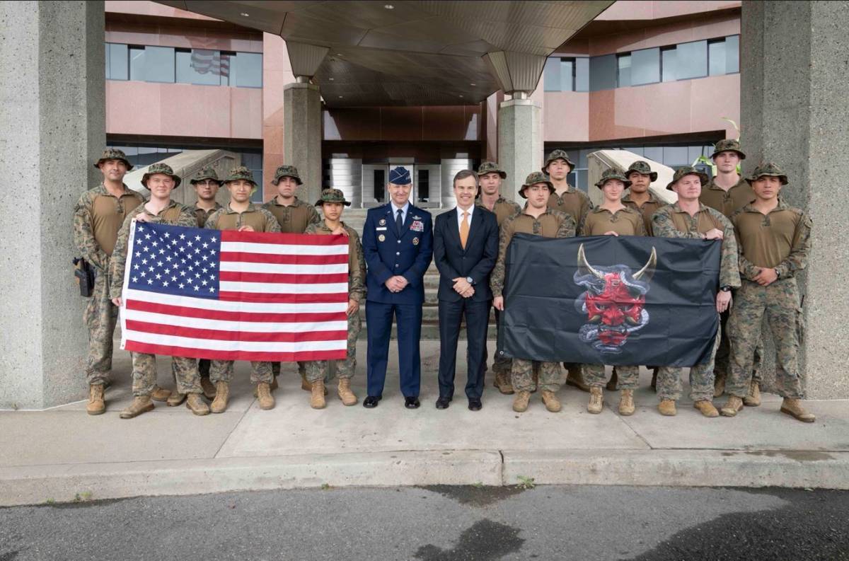 El general Dan "Razin" Caine y el encargado de Negocios en la Embajada John M. Barrett junto a los integrantes de la Unidad de Aumento de Seguridad de Marines. (Cr�ditos: The Joint Staff)           